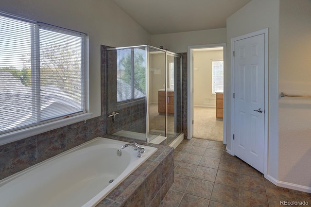 bathroom featuring healthy amount of natural light, a stall shower, a garden tub, tile patterned flooring, and vaulted ceiling