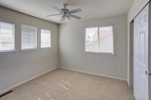 unfurnished bedroom with carpet, multiple windows, a closet, and baseboards