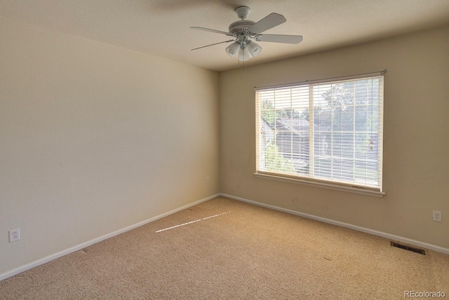 unfurnished room with light colored carpet, ceiling fan, and baseboards