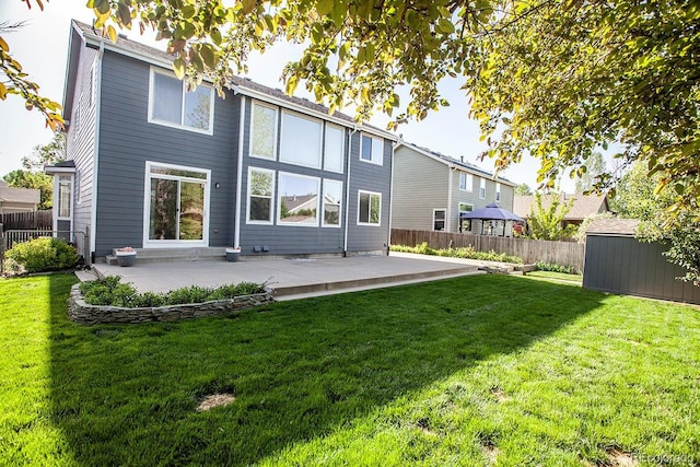 back of house featuring a patio, a storage shed, and an outdoor structure