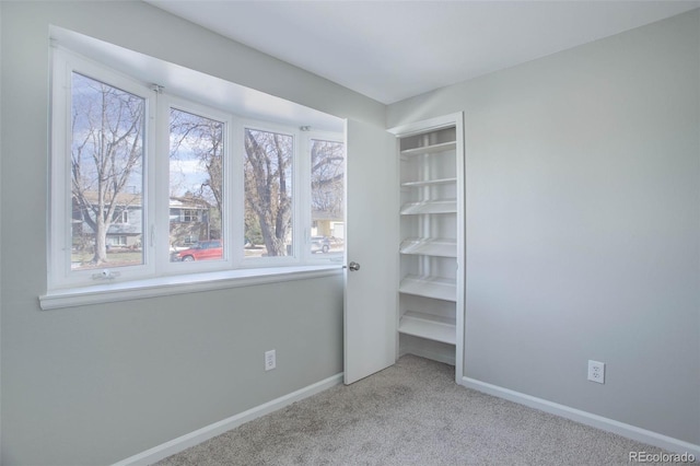 unfurnished bedroom featuring light carpet and multiple windows