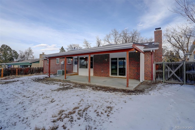 snow covered house featuring a patio