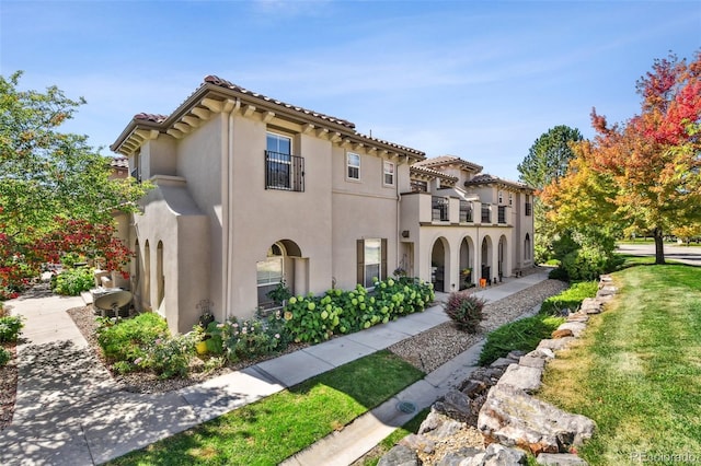 exterior space featuring a front yard and a balcony