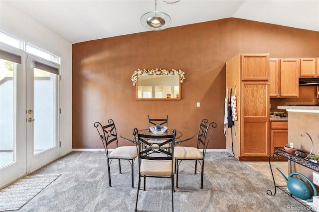 carpeted dining area featuring lofted ceiling and french doors