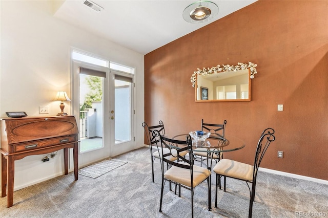 carpeted dining space with french doors