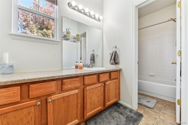 bathroom featuring tile patterned flooring, tiled shower / bath, and vanity