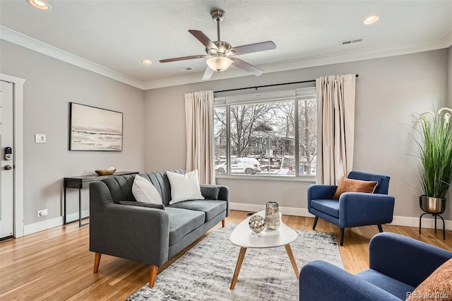 living room featuring crown molding, ceiling fan, and light wood-type flooring