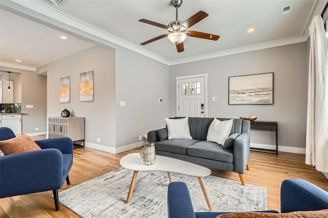 living room featuring ornamental molding, ceiling fan, and light hardwood / wood-style flooring