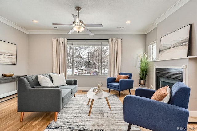 living room with crown molding, plenty of natural light, and hardwood / wood-style floors