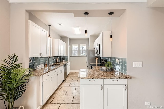 kitchen with sink, white cabinetry, stone counters, stainless steel appliances, and backsplash