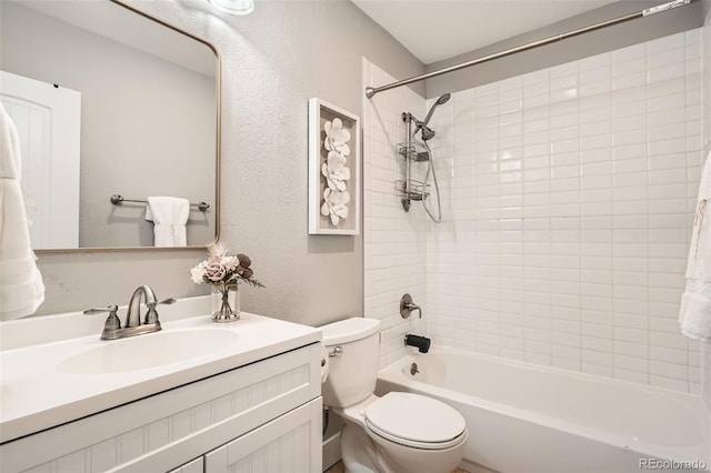 full bathroom featuring tiled shower / bath combo, vanity, and toilet