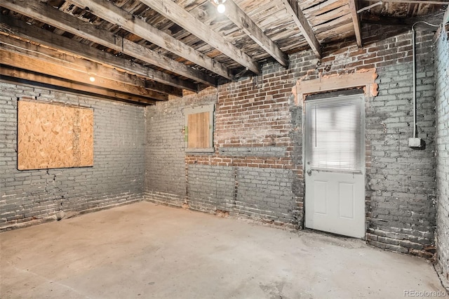 interior space featuring brick wall and concrete floors