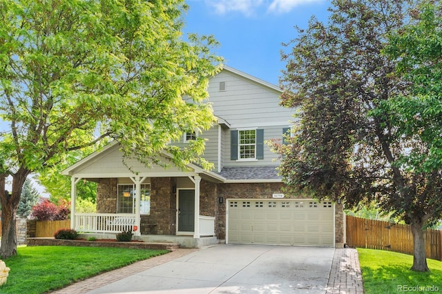 14794 Vine St, Thornton, CO 80602 - view of front of home with driveway, a garage, covered porch, and stone siding