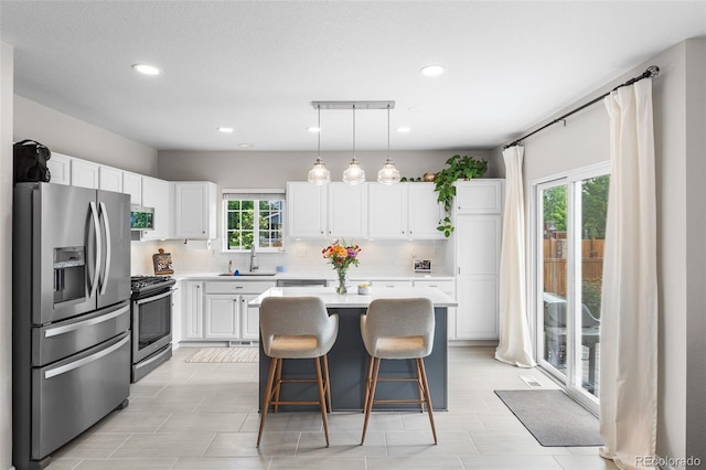 14794 Vine St, Thornton, CO 80602 - kitchen with stainless steel appliances, a sink, light countertops, white cabinets, and a kitchen bar