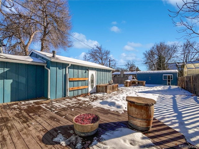 snow covered deck with an outdoor structure and a jacuzzi