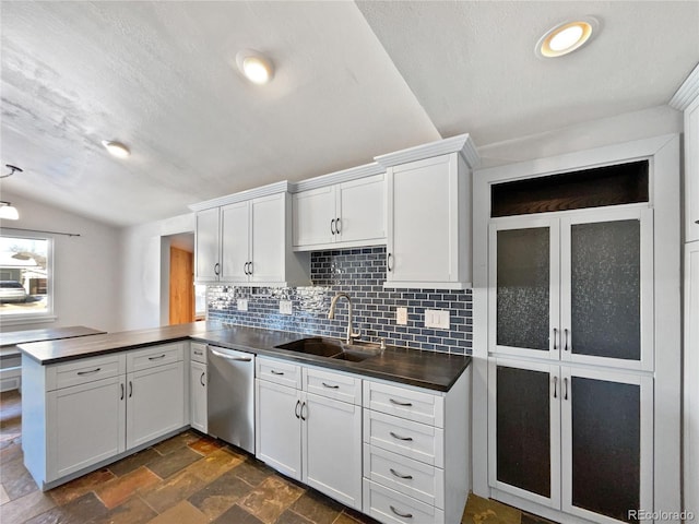 kitchen with lofted ceiling, stainless steel dishwasher, kitchen peninsula, and white cabinets