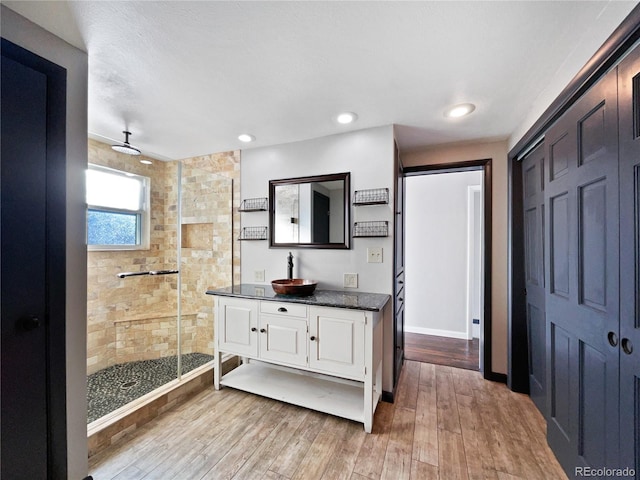 bathroom featuring hardwood / wood-style flooring, vanity, and a shower with shower door