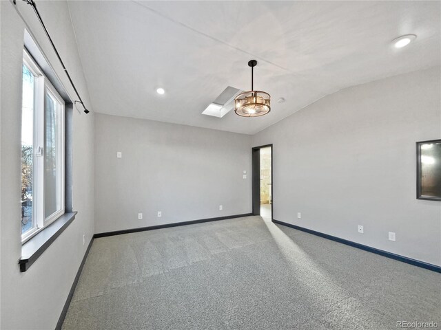 carpeted spare room featuring lofted ceiling and plenty of natural light