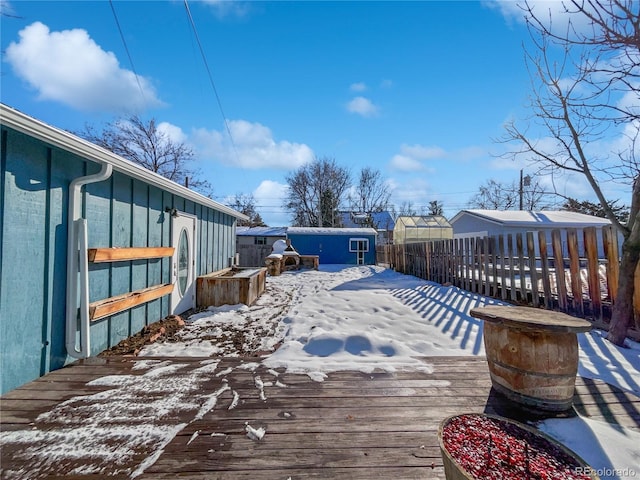 snow covered deck featuring a storage shed