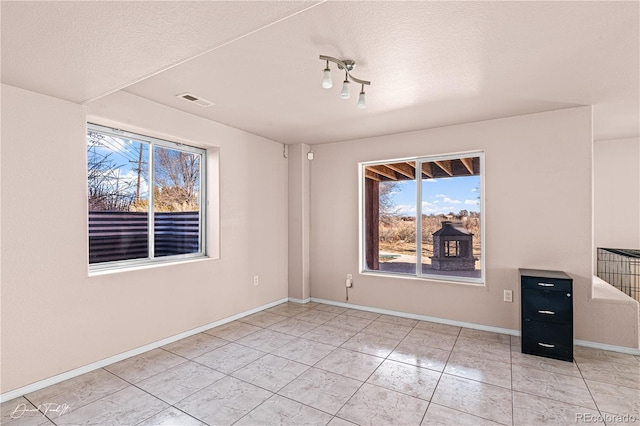 25 Tierra Casa Dr, Pueblo, CO 81005 - empty room with plenty of natural light, a textured ceiling, and light tile patterned floors