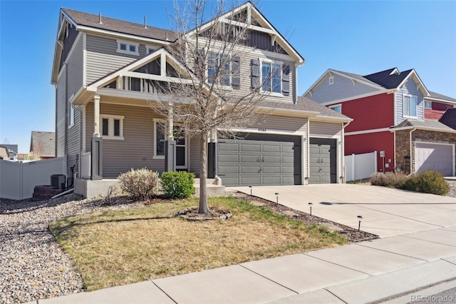view of front facade featuring fence, driveway, cooling unit, and a garage