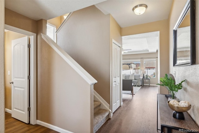 stairs featuring wood finished floors and baseboards