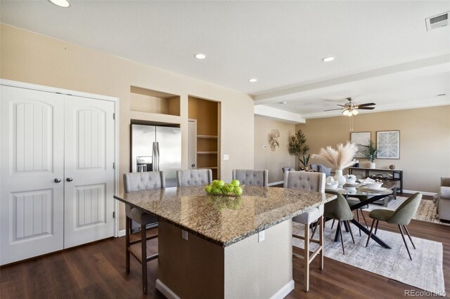 kitchen with recessed lighting, dark wood-style floors, stainless steel fridge with ice dispenser, a breakfast bar, and visible vents