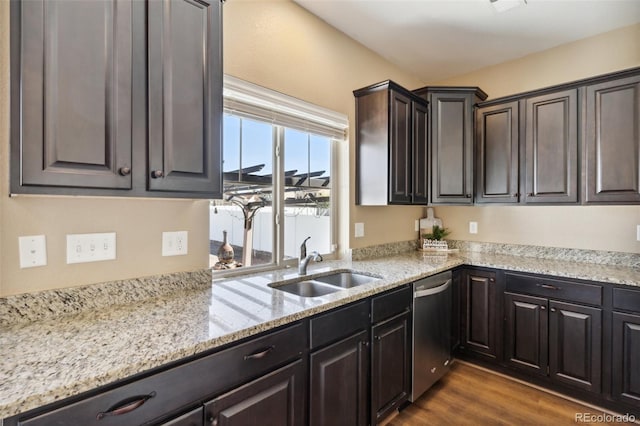 kitchen featuring dishwasher, light stone countertops, dark wood-style floors, and a sink