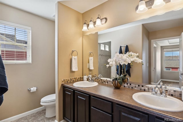 full bath with toilet, a sink, and plenty of natural light