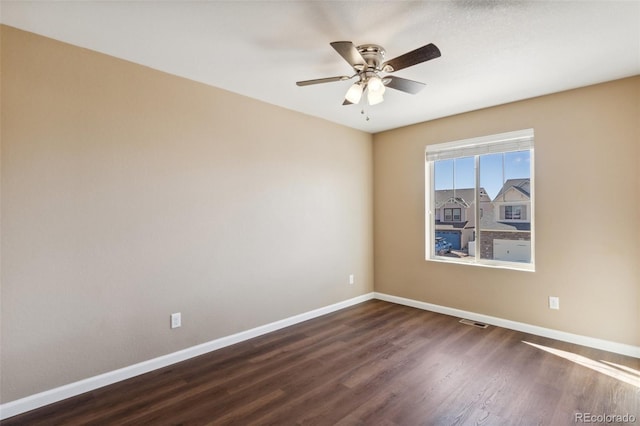 empty room with ceiling fan, baseboards, dark wood-style flooring, and visible vents