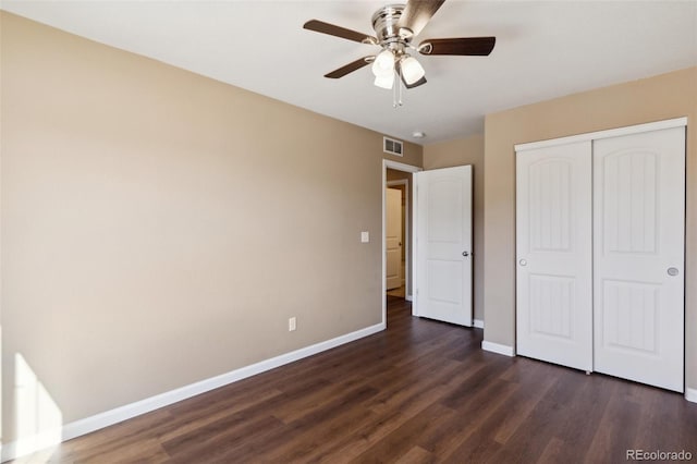 unfurnished bedroom with dark wood finished floors, visible vents, a ceiling fan, a closet, and baseboards