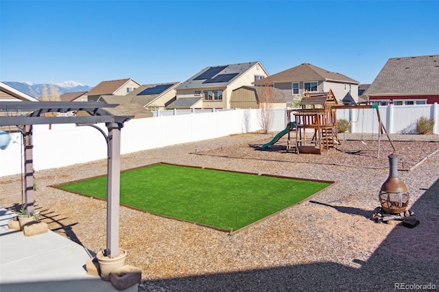 view of play area with a pergola, a residential view, and a fenced backyard