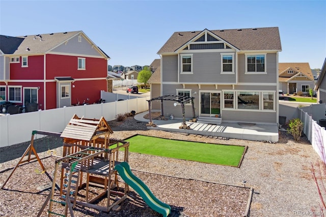 back of house featuring a patio area, a fenced backyard, and a playground