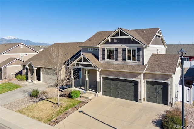 craftsman house with concrete driveway, a shingled roof, fence, a mountain view, and a garage