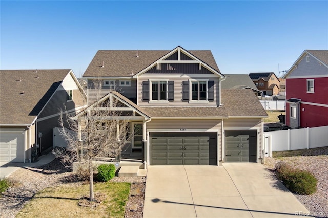 craftsman-style house featuring concrete driveway, a shingled roof, an attached garage, fence, and a residential view