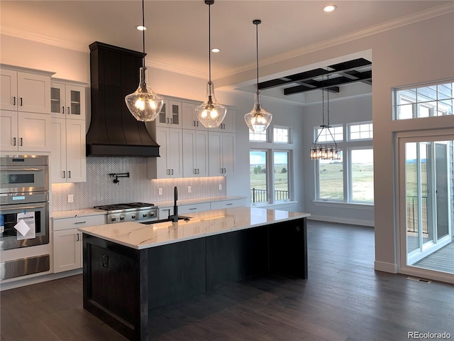 kitchen with white cabinets, dark hardwood / wood-style flooring, and a kitchen island with sink