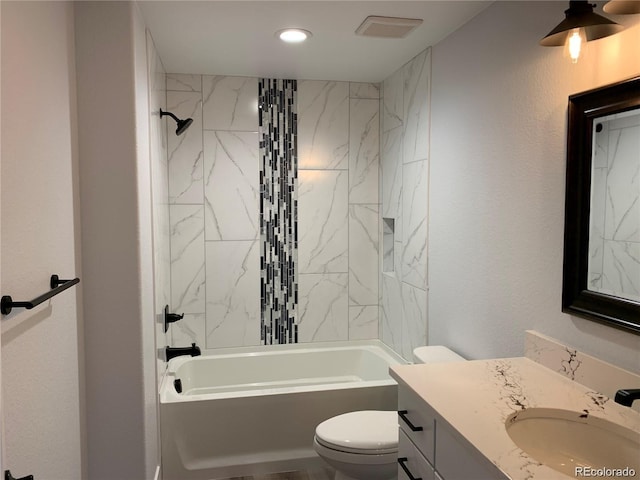 full bathroom with vanity, tiled shower / bath, and toilet