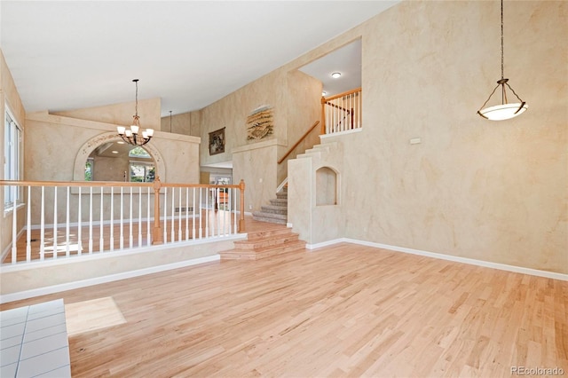 6846 Edgewood Way, Highlands Ranch, CO 80130 - unfurnished room with wood finished floors, a chandelier, stairway, and high vaulted ceiling