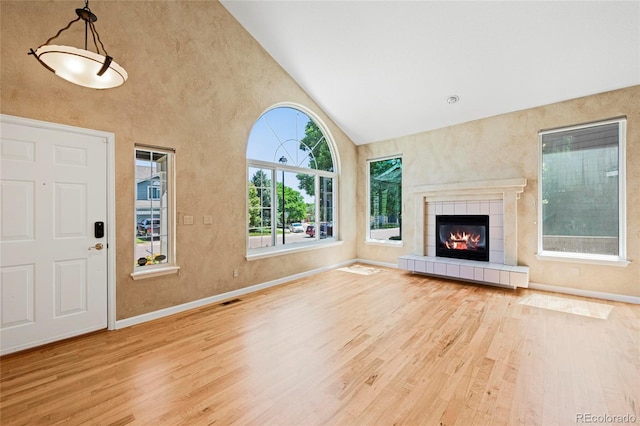 6846 Edgewood Way, Highlands Ranch, CO 80130 - unfurnished living room with wood finished floors, high vaulted ceiling, and a fireplace