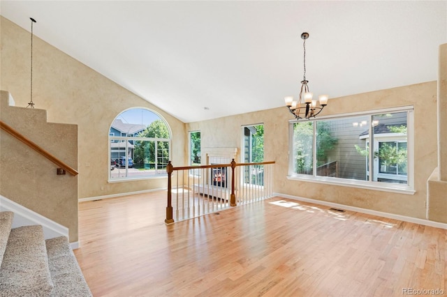 6846 Edgewood Way, Highlands Ranch, CO 80130 - spare room featuring plenty of natural light, wood finished floors, a chandelier, and high vaulted ceiling