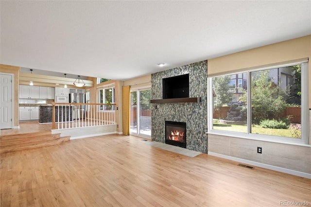 6846 Edgewood Way, Highlands Ranch, CO 80130 - unfurnished living room featuring light wood-style floors and a fireplace