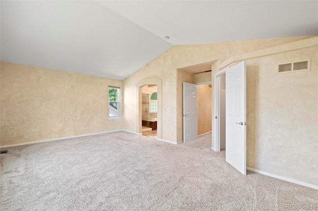6846 Edgewood Way, Highlands Ranch, CO 80130 - unfurnished bedroom featuring lofted ceiling, carpet floors, arched walkways, and ensuite bathroom