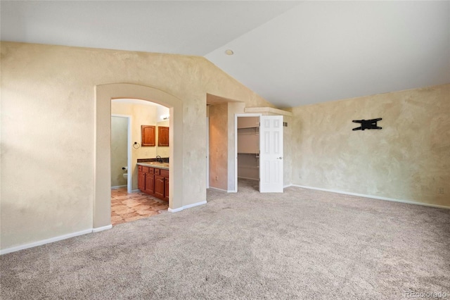 6846 Edgewood Way, Highlands Ranch, CO 80130 - unfurnished living room featuring vaulted ceiling, arched walkways, and light colored carpet