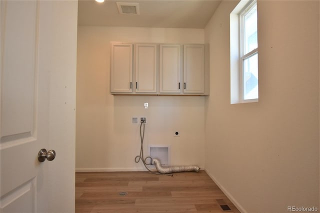 washroom featuring light hardwood / wood-style floors, hookup for an electric dryer, and plenty of natural light