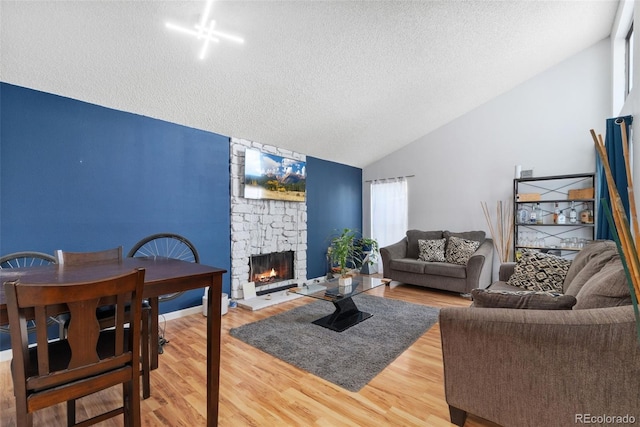 3874 S Fraser St Unit P11, Aurora, CO 80014 - living area featuring lofted ceiling, a textured ceiling, a fireplace, wood finished floors, and healthy amount of natural light