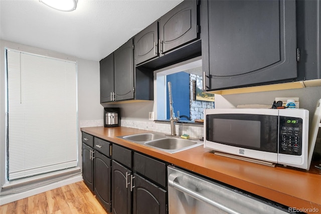 3874 S Fraser St Unit P11, Aurora, CO 80014 - kitchen with dishwasher, light wood finished floors, light countertops, and tasteful backsplash
