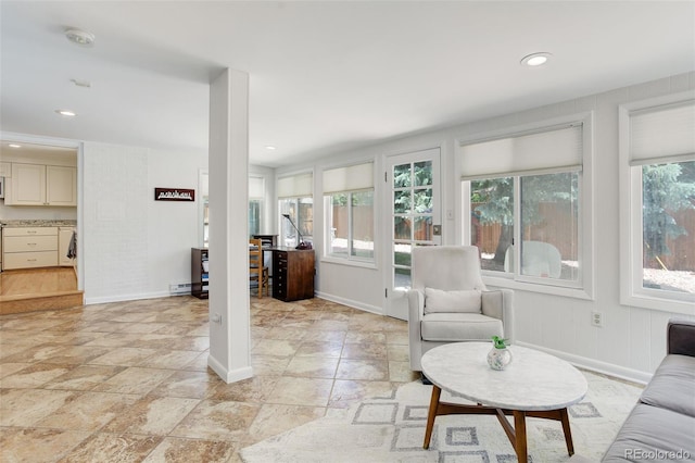 3090 S High St, Denver, CO 80210 - living area with light stone finish flooring, baseboards, recessed lighting, and a baseboard heating unit