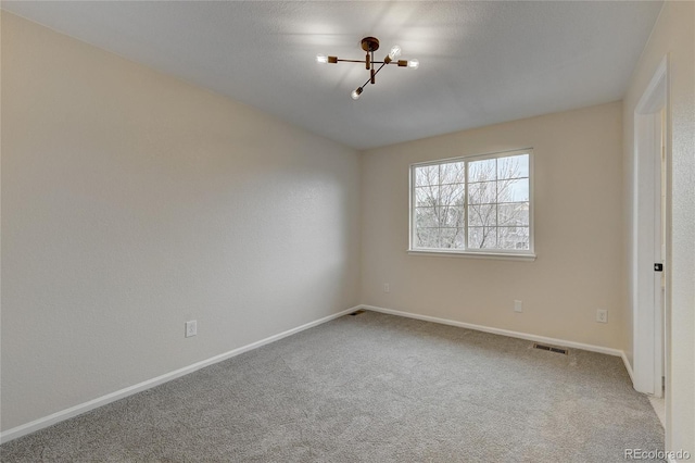 unfurnished room featuring carpet and a chandelier