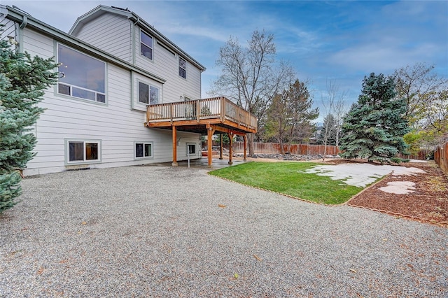 back of house featuring a lawn, a patio area, and a deck