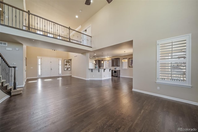 unfurnished living room with dark hardwood / wood-style floors and a high ceiling